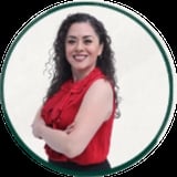 Professional portrait of a smiling woman with long curly dark hair wearing a red sleeveless top, arms crossed